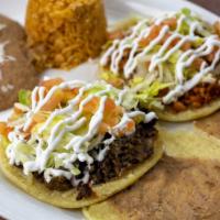 Dos Gorditas Con Arroz Y Frijoles · Two gorditas with Mexican rice and re fried beans.