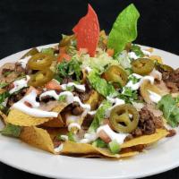 Nachos Mexicanos · Crisp tortilla chips topped with melted chihuahua cheese, beans, jalapeno peppers, sour crea...