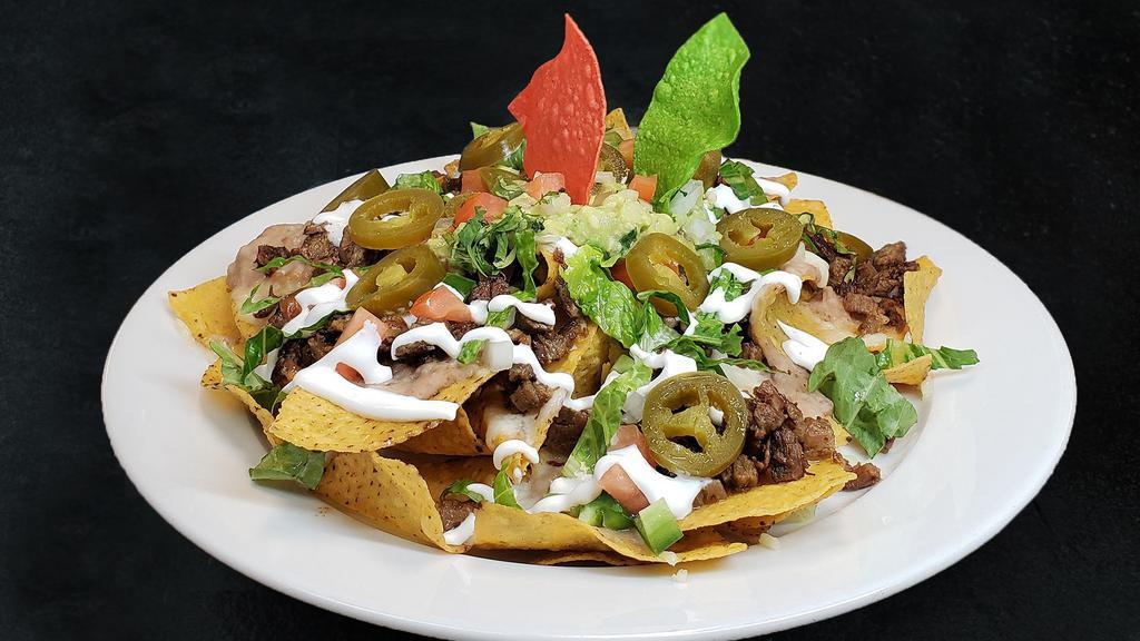 Nachos Mexicanos · Crisp tortilla chips topped with melted chihuahua cheese, beans, jalapeno peppers, sour cream, guacamole, lettuce, pico de gallo, and choice of meat.