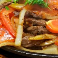 Lomo Saltado · Grilled steak sauteed with onions, tomatoes, & french fries