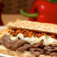 Beef Deluxe Panino · Italian beef on garlic bread topped with sweet or hot peppers and melted mozzarella.
