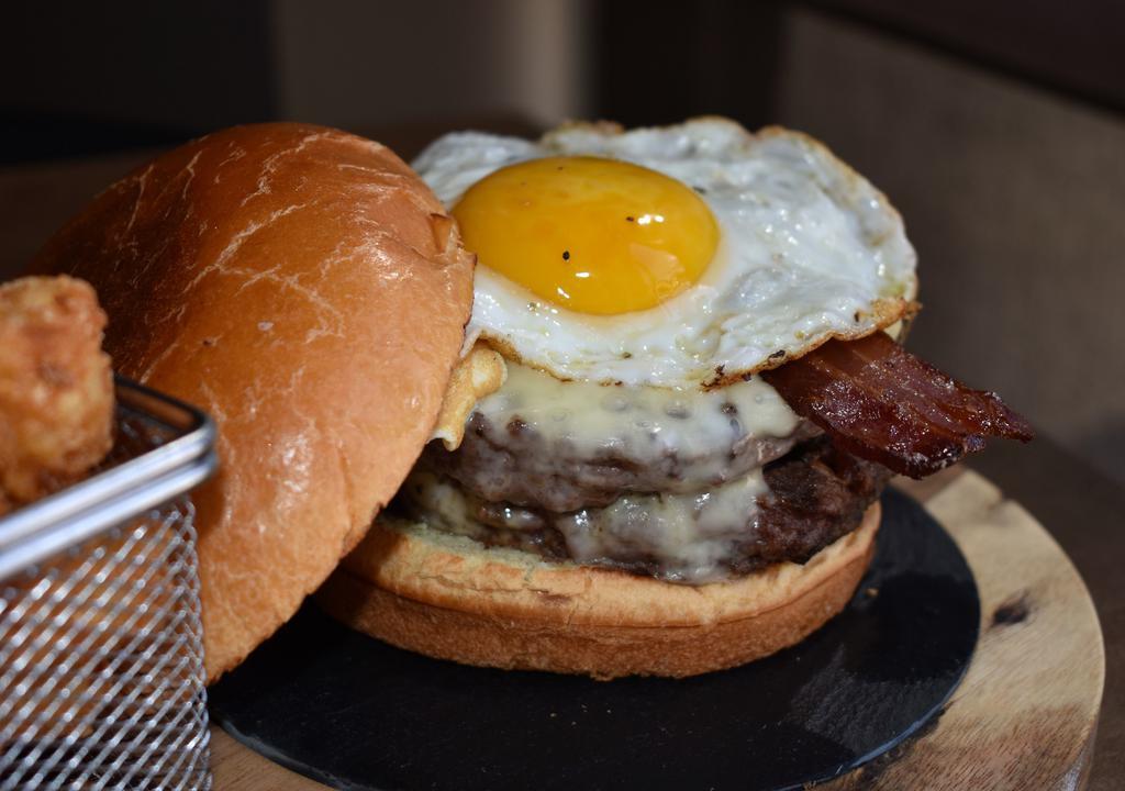 Sunny Side Up Burger · 10oz burger, sunny side up egg, cheddar cheese, Applewood smoked bacon, lettuce, and tomato.
