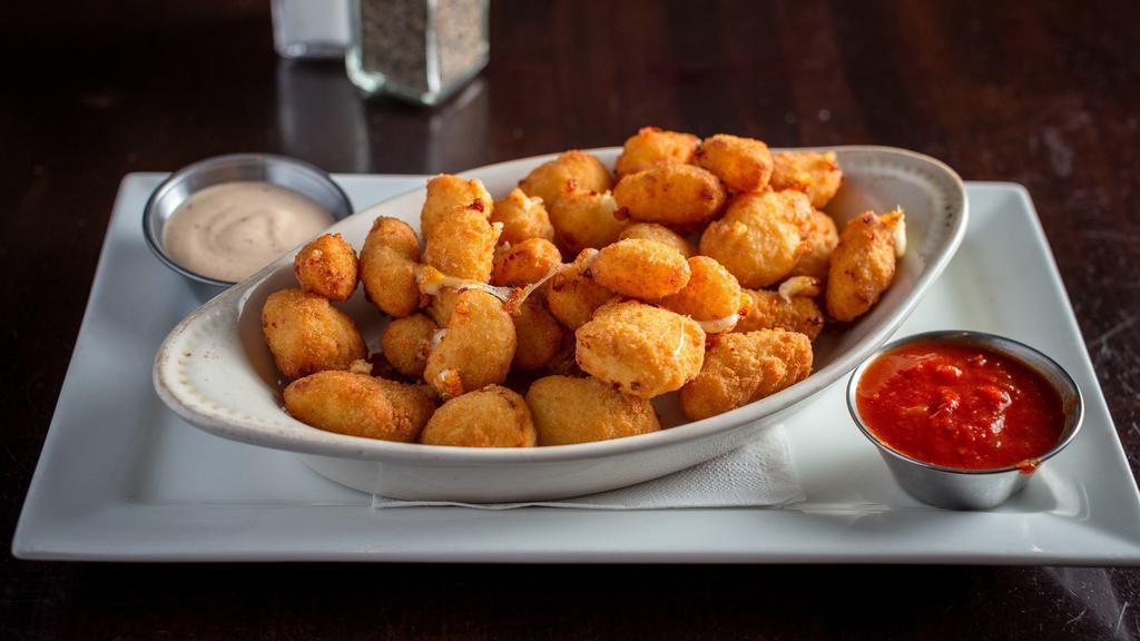 Hand Battered Cheese Curds · Wisconsin white cheddar curds, served with marinara sauce and chipotle ranch.