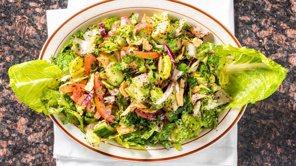 Fattoush Salad · Romaine lettuce, tomato, onion, crisp cucumber, tossed with freshly toasted pita chips, and sumac in our dressing.