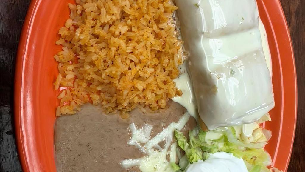 Chimichanga · With your meat choice of: carnitas, ground beef, shredded chicken, shredded beef topped with cheese sauce. Served with rice, refried beans, sour cream and pico de gallo.