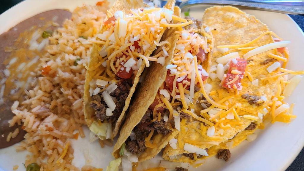 Taco Dinner · Three crispy or soft tacos with shredded Cheese, lettuce and tomato. Served with rice, refried beans and your choice of meat: ground beef, shredded beef, shredded chicken.