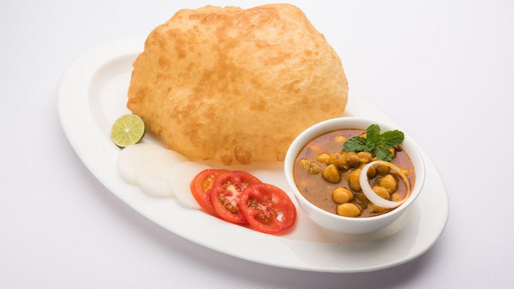 Chole Bhature · A tangy chickpea curry served with your choice of naan, roti, poori or bhatura (deep fried leavened sourdough flatbread).