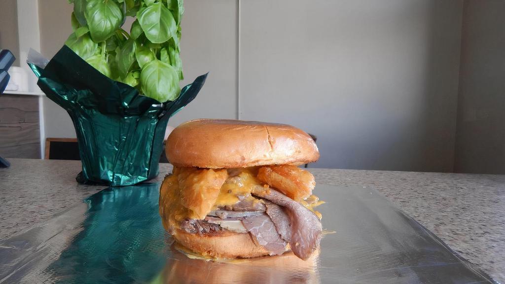 The Spicy Beef And Cheddar · Slow roasted beef piled high on a toasted Brioche Bun and topped with spicy nacho cheese and a crispy onion ring.