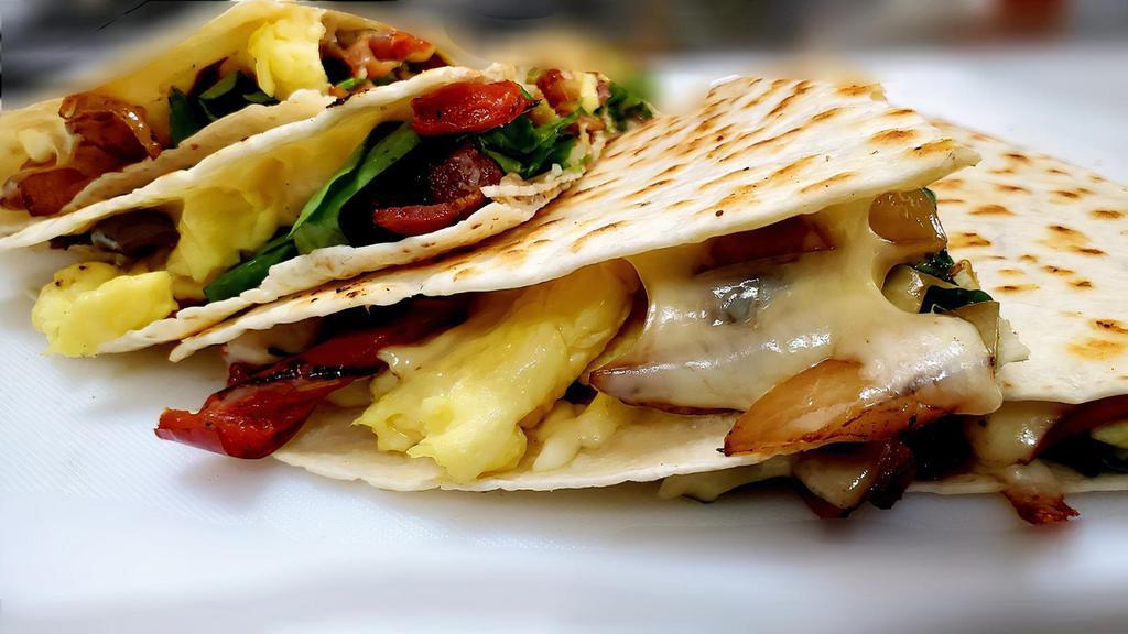Breakfast Quesadilla · Spinach, bell peppers, onions, eggs, bacon, Chihuahua cheese, with a side of mild salsa on a  flour tortilla.