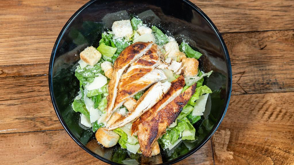 Caesar Salad · Crispy romaine lettuce, grilled chicken breast, croutons, Parmesan cheese, with a side of our creamy Caesar dressing.