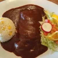 Pollo En Mole Veracruzano · Chicken breast topped with homemade mole poblano and served with white rice, salad and torti...