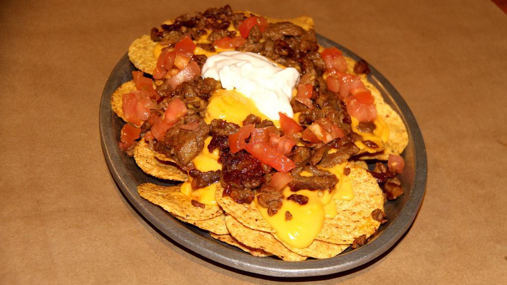 Nachos Supreme · Served with nachos chips ,cheddar cheese, tomato, sour cream, & your choice of meat. Feeds 2-3 people.