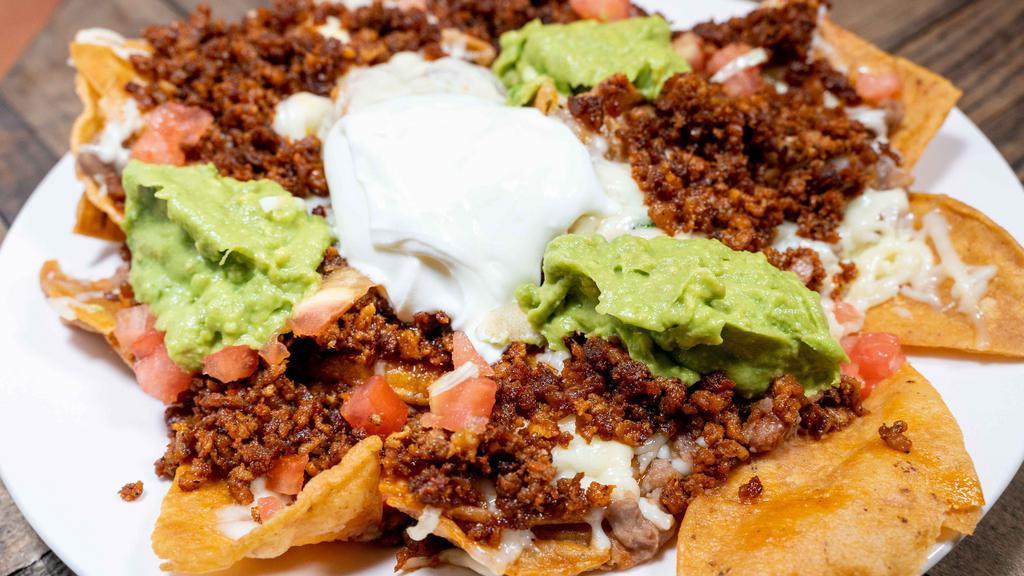 Nachos Rancho Grande · Served with home made chips beans, melted cheese, guacamole, tomato, & sour cream. Feed 2-3 people.