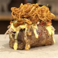 Nacho Potato · Giant baked potato topped with homemade cheese sauce, jalapeños, tomatoes, pulled pork, and ...