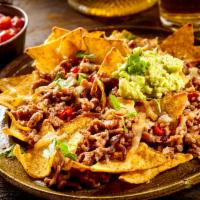 Nachos Beef · Ground Beef nachos serve with tortilla chips, cheese, salsa, guacamole, sour cream, and pick...