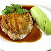 Roast Duck Over Rice · Sliced roasted duck and black soy sauce gravy over steamed white rice and cucumber on the si...