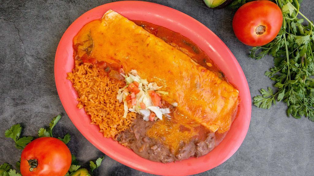 Burrito Mojado/Wet Burrito · burrito filed with beans your choice of meat onions cilantro topped with tomatoes home made sauce  melted cheese and side rice and beans.