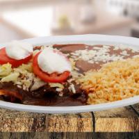 Mexican Enchilada / Enchiladas Mexicanas · Served with lettuce, cheese and sour cream, rice and beans. / Servido con lechuga, queso, cr...