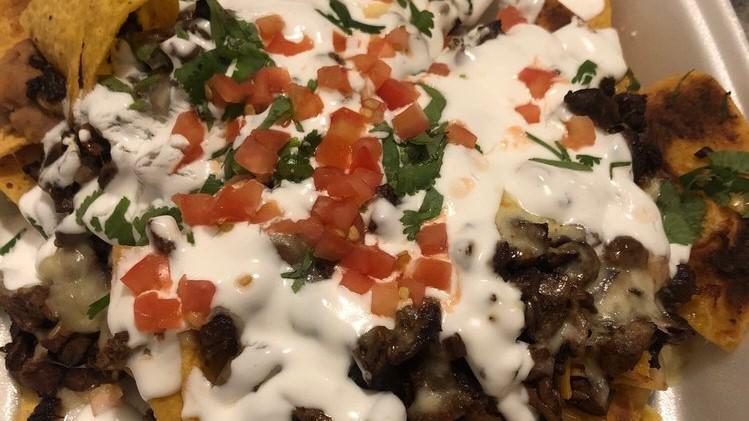 Nachos With Meat · Tortilla chips, beans, chihuahua cheese, sour cream, and guacamole.