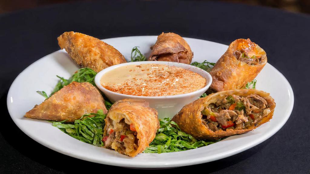 Philly Cheese Steak Egg Rolls · Shaved sirloin, provolone, and mozzarella cheese blend, peppers and onions, pepper jack queso, wonton wrapper.