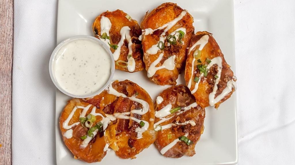 Potato Skins · Six piping hot skins topped with shredded cheddar cheese, bacon crumble, chives & drizzled with sour cream.
