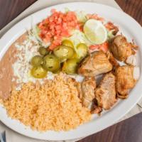 Carnitas · Pork chunks served with rice, beans, guacamole salad, and tortillas.