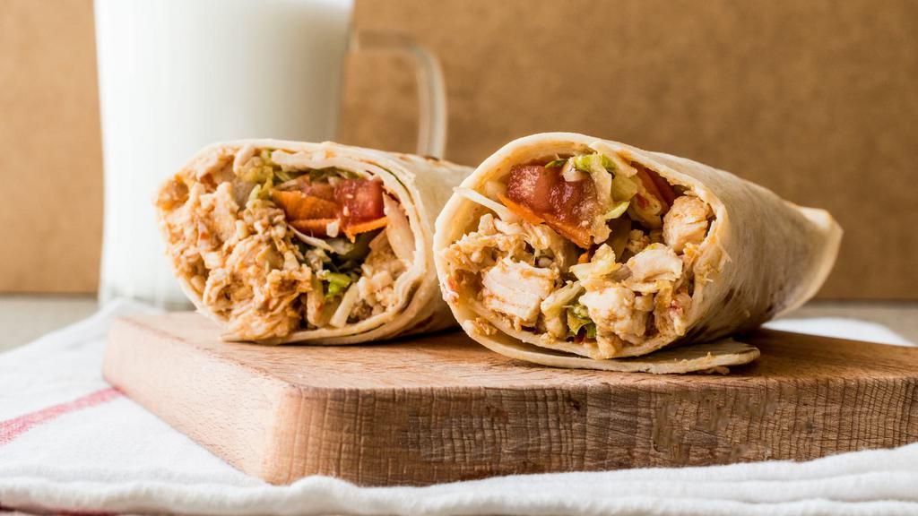 Chicken Shawarma Pita Sandwich · Delicious chicken shawarma strips with pickles, tomatoes, and garlic sauce wrapped in pita sandwich.