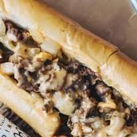 Cheeseless Steak · Sliced steak with grilled onions on a hoagie roll.