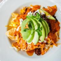 Chilaquiles · Tortilla chips, mixed with scrambled eggs, red sauce, and black beans. Topped with chorizo, ...
