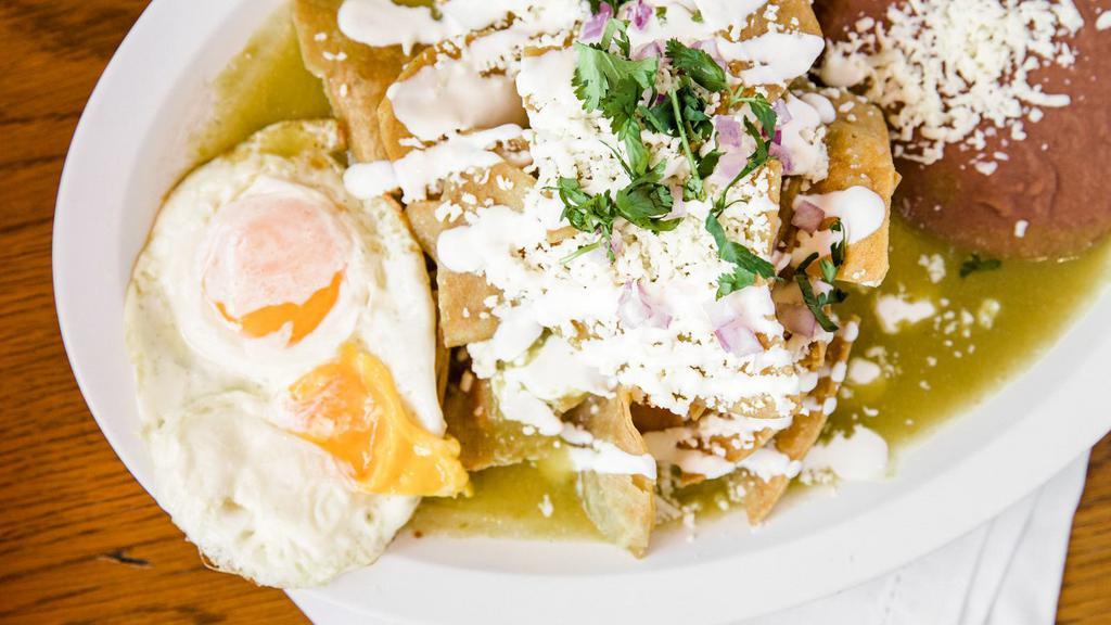 Chilaquiles · Popular Mexican breakfast served with two eggs, fried tortillas chips, covered in a mild green or spicy red salsa, a side of beans, topped off with sour cream, queso fresco, onions, and cilantro and steak .