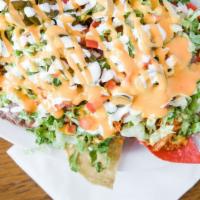 Nachos · Fried tortilla chips covered with lettuce, tomatoes, melted nacho cheese, beans, jalapenos, ...
