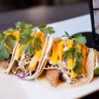 Mahi Tacos (3) · Fresh mahi flash fried, placed in a soft corn tortilla, topped with an apricot glaze, zesty ...