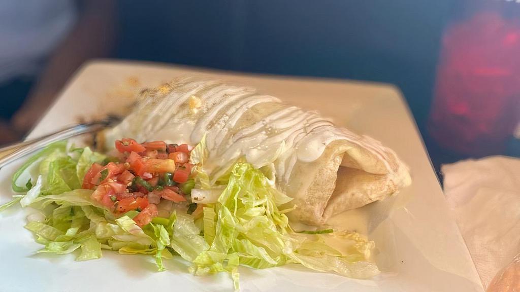 Ohio Burrito · Flour tortilla stuffed with steak or chicken, rice and black beans. Served with lettuce, pico de gallo and chipotle sauce. Red sauce, cheese sauce.
