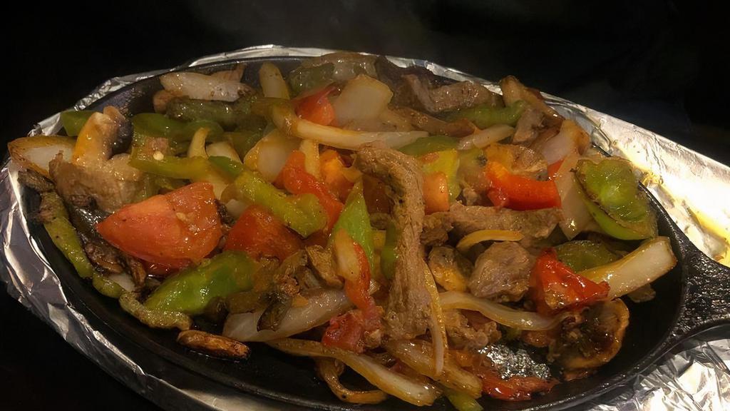 Steak · All fajitas are cooked with mushrooms, onions, tomatoes and bell peppers. Served with rice, beans, guacamole salad, sour cream and pico de gallo.