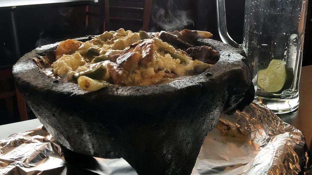 Molcajete Monterrey · Tender slices of steak, chicken, chorizo and shrimp, grilled with Mexican onions and nopal (cactus), marinated in green sauce and covered with cheese. Served in a traditional 