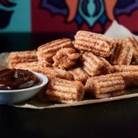 Churro Bites · Fried dough pastries dusted with cinnamon sugar and served with chocolate dipping sauce.