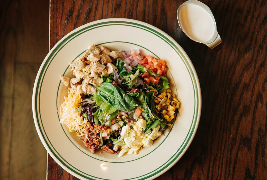 Cobb Salad · Mixed greens, crumbled bacon, red onions, chicken, hard boiled egg, tomatoes, shredded cheddar jack, with choice of dressing.