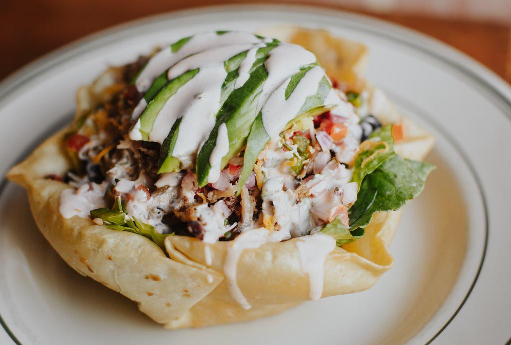 Smoked Pork Taco Salad · Lettuce, Pico de Gallo, Pulled Pork, Black Beans, Shredded Cheese, Avocado, in a Fried Tortilla Shell. Served with Spicy Ranch Dressing.