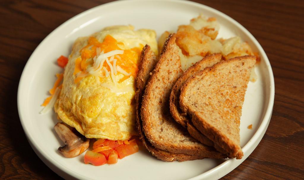 Veggie Omelet · Three-egg omelet with seasonal vegetables, mozzarella & cheddar cheeses. Your choice of side and toast.