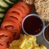 Mid Kitchen · Two eggs any style, sliced tomato and cucumber, homemade hazelnut chocolate spread, honey, P...