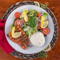 Fillet Of Atlantic Salmon · Grilled fresh fillet of salmon topped with a feta dill sauce, served with a mixed green sala...