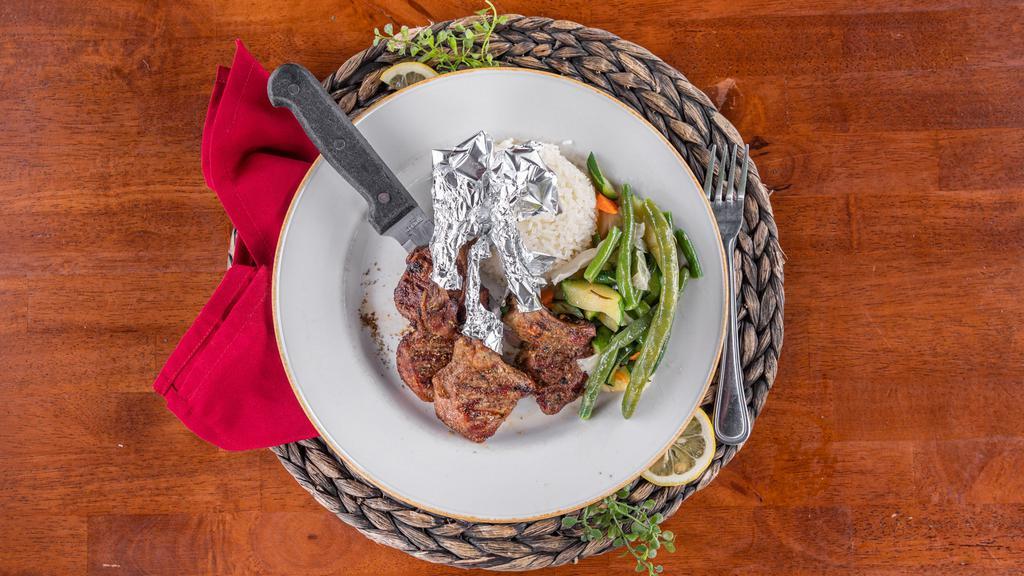 Lamb Chops · Delicately marinated and char-broiled lamb chops topped with oregano leaves.