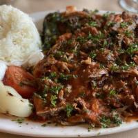 Iskender Kebab · Slices of doner kebab over toasted garlic bread, served with yogurt and tomato sauce.