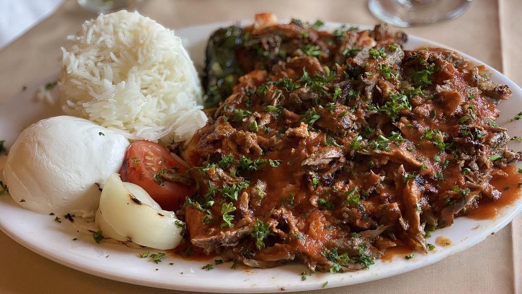 Iskender Kebab · Slices of doner kebab over toasted garlic bread, served with yogurt and tomato sauce.