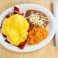 Chilaquiles Con Huevo · Tortilla strips dipped in hot sauce with three eggs.