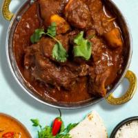 The Famous Goat Vindaloo · Bone-in goat meat cooked in our special housemade curry masala, dry chili, red and yellow di...