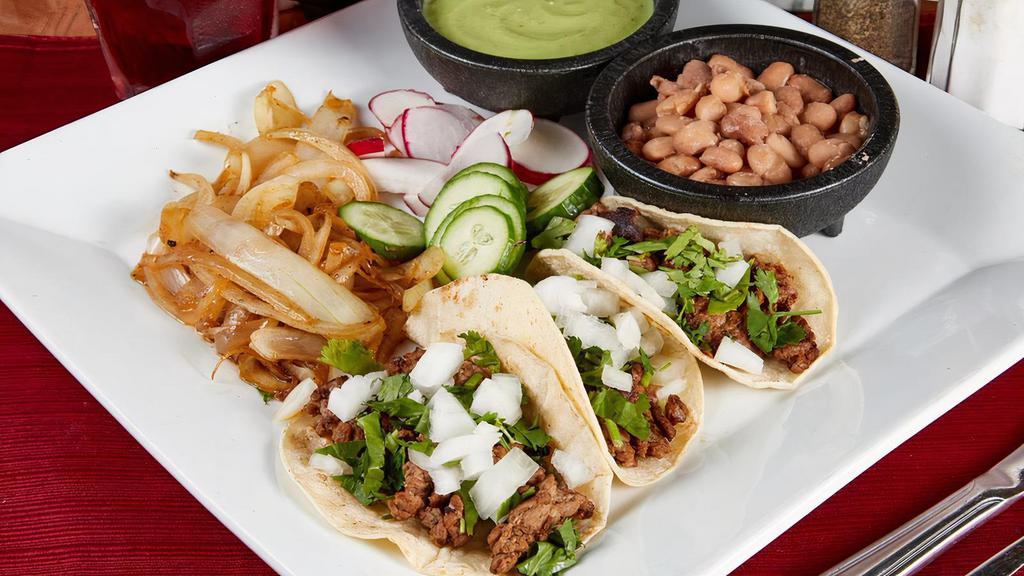 Authentic Street Tacos · (Order of 3) Your choice of meat. Topped with onion & cilantro. Served with a side of your choice.