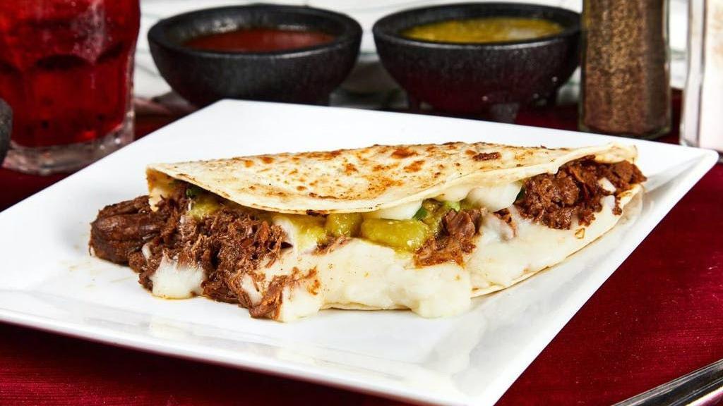 Suiza · Large flour tortilla stuffed with cheese, costilla (beef spare ribs), onion, cilantro and green salsa; folded in half and gently cooked on the grill. Served with a side of your choice.