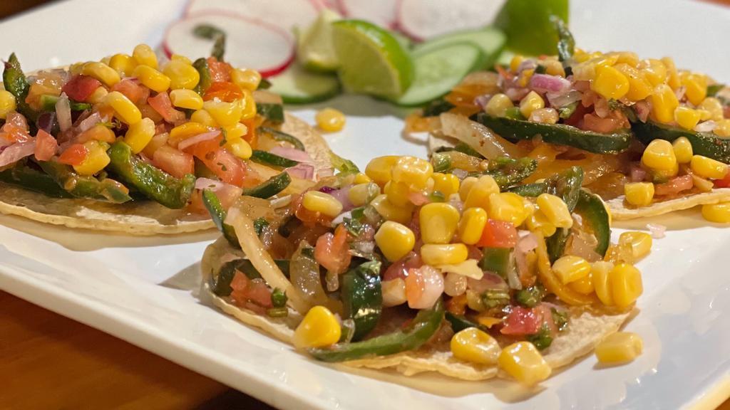 Vegan Tacos Poblanos · Fried Poblano pepper, sauteed onions and tomato topped with Pico de mango, and corn.  Served with a side of your choice.