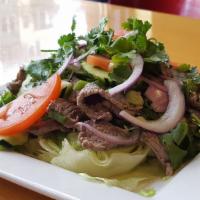 Erawan Steak Salad · Low-fat, gluten-free. Thinly sliced beef tenderloin over a bed of lettuce, tomatoes, cucumbe...
